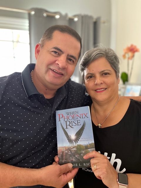 Man and A Woman Happily Holding The Book