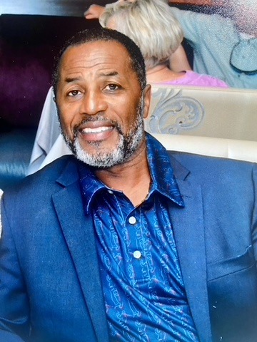 Smiling man with a beard and blue shirt