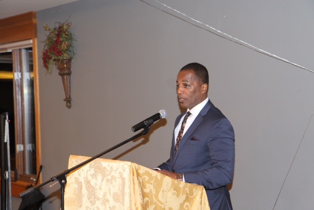 A man speaks at a podium addressing an audience