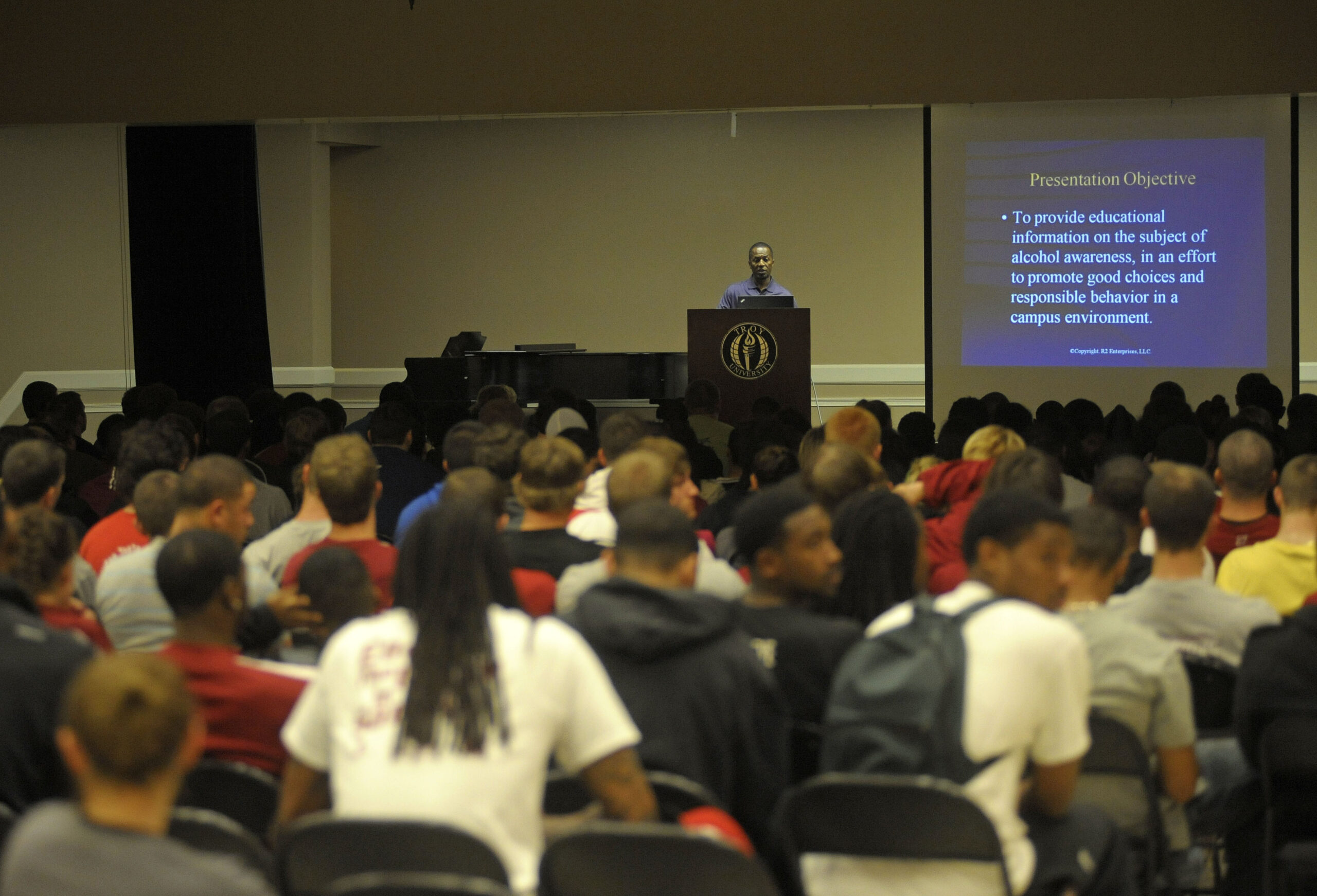 A speaker addresses a large audience