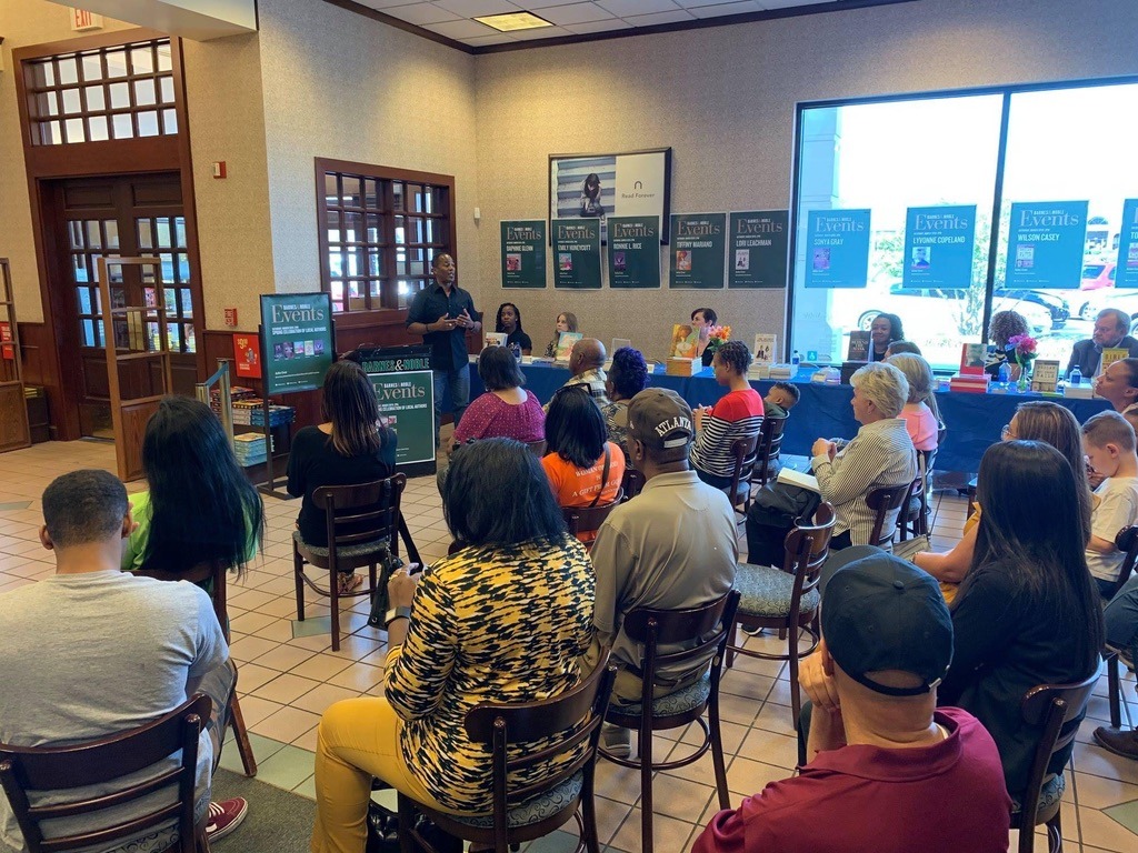 A speaker addresses an audience in a bookstore